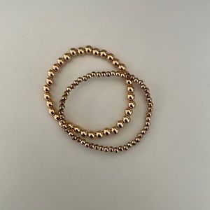 2 gold beaded bracelets.